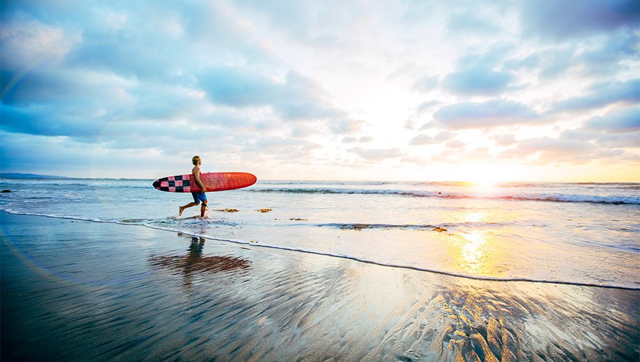 Obraz przedstawiający surfera patrzącego na morze horyzont